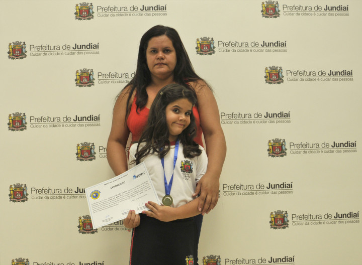 Larissa, com a mãe Vanessa, mostra o certificado: multiplicadora