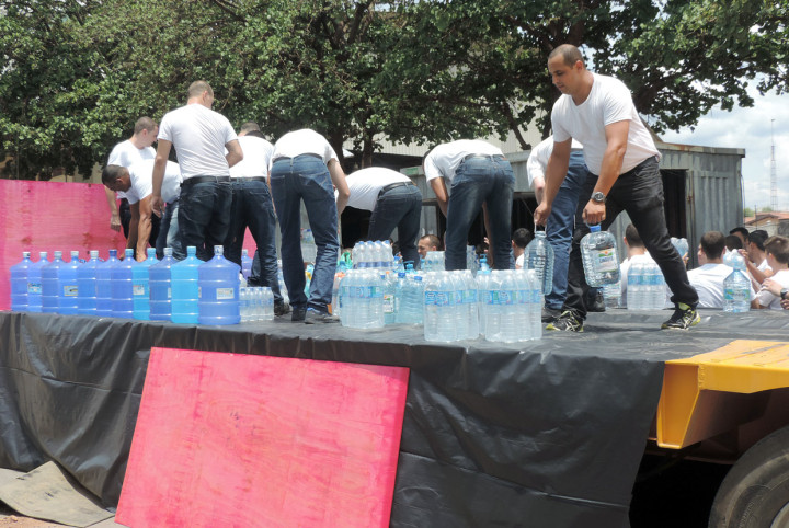 Futuros guardas municipais ajudam no carregamento de litros de água