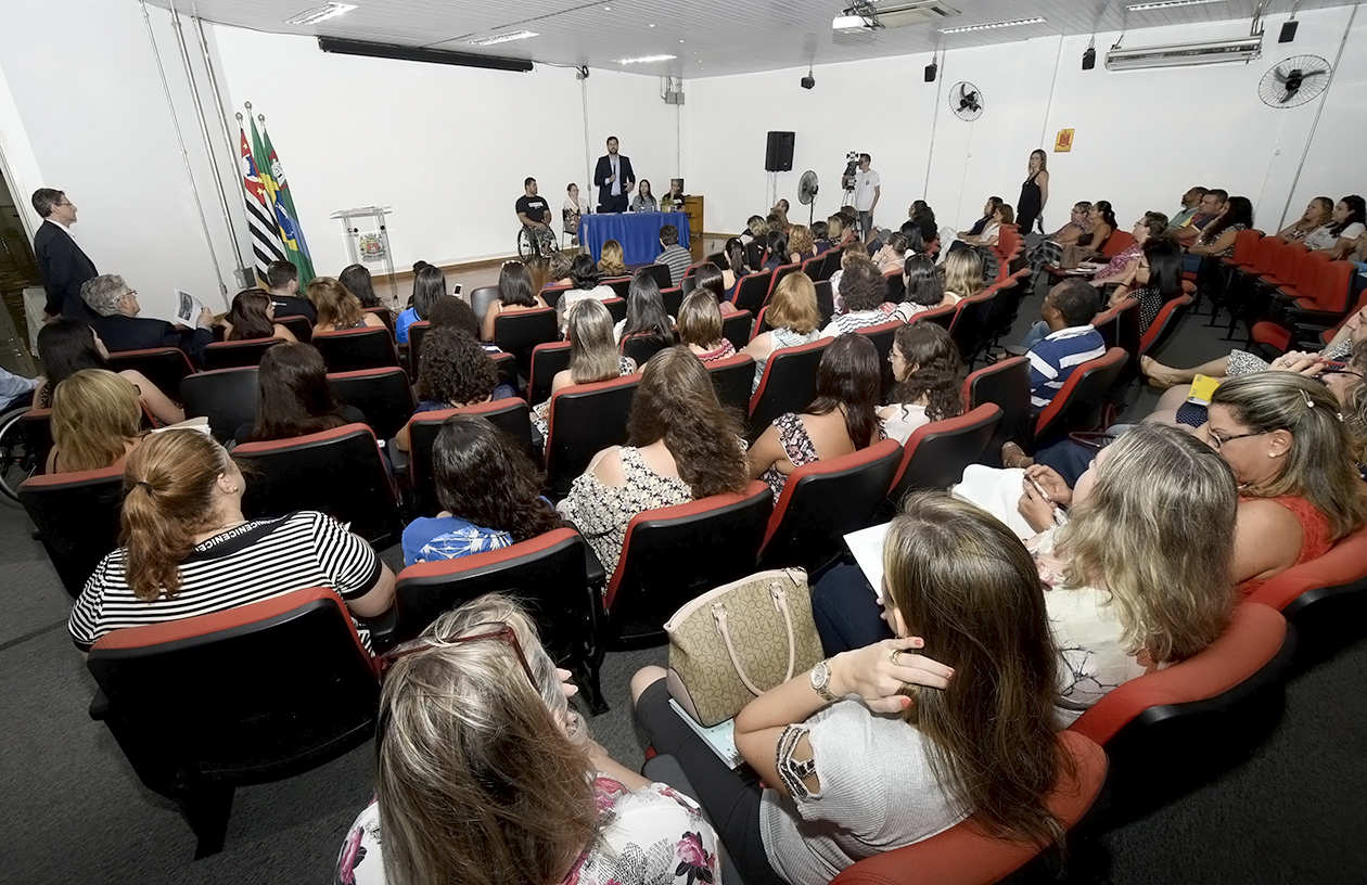 Formatura do Funss, com alunos sentados em um auditório. O prefeito Luiz Fernando fala ao microfone para a plateia