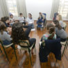 Crianças sentadas em círculo durante uma oficina na Sala Hermeto Pascoal do Complexo Fepasa