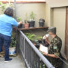 Moradora mostra vaso enquanto militar verifica um frasco