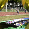 Foto feita entre medalhas com foco em atleta na pista de atletismo