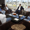 Foto da sala de trabalho do prefeito, com representantes da comitiva e gestores da Prefeitura sentados e panorama de Jundiaí visto da janela