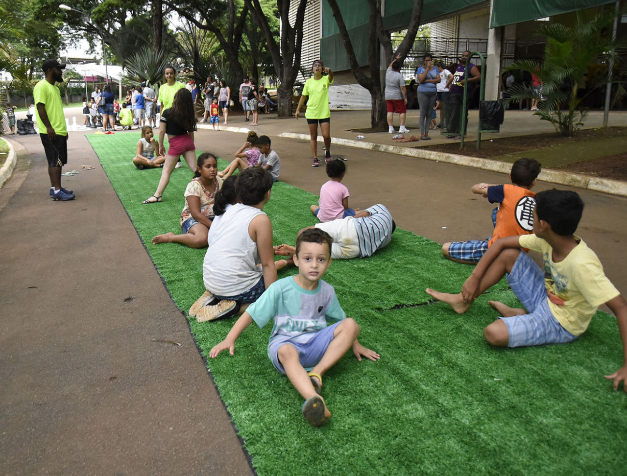 Crianças, sob a orientação de monitores, se divertem em uma estação do Ruas de Brincar montada em frente ao pavilhão do Parque