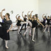 Bailarina Ana Botafogo com bailarinas acompanhando com o olhar e passos de dança, em sala de ensaio