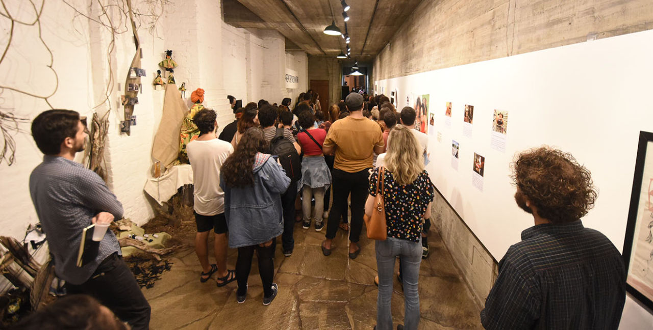 Galeria de Arte, com mostra e expectadores no corredor