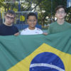 Três crianças seguram bandeira do Brasil