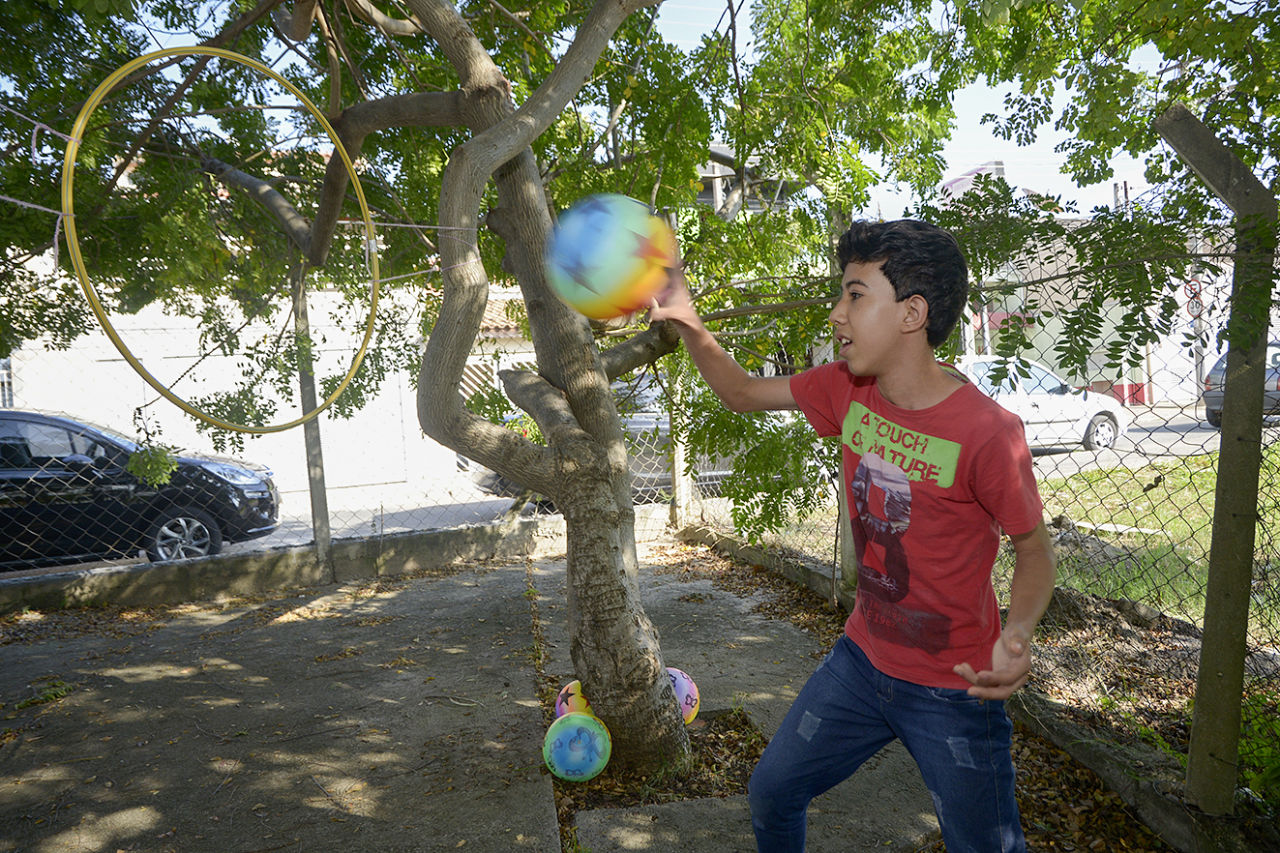 Grupo de Estimulação Infantil, garoto lança bola em arco
