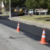 Rua com asfalto novo e cones de sinalização