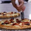 Pizza sendo cortada