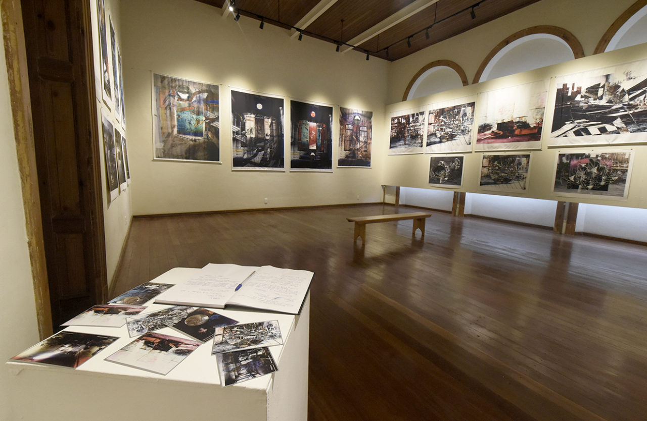 Sala de exposição, com obras de arte abstratas penduradas