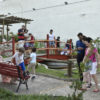 Jardim com ponte sobre tanque de água, com adultos e crianças
