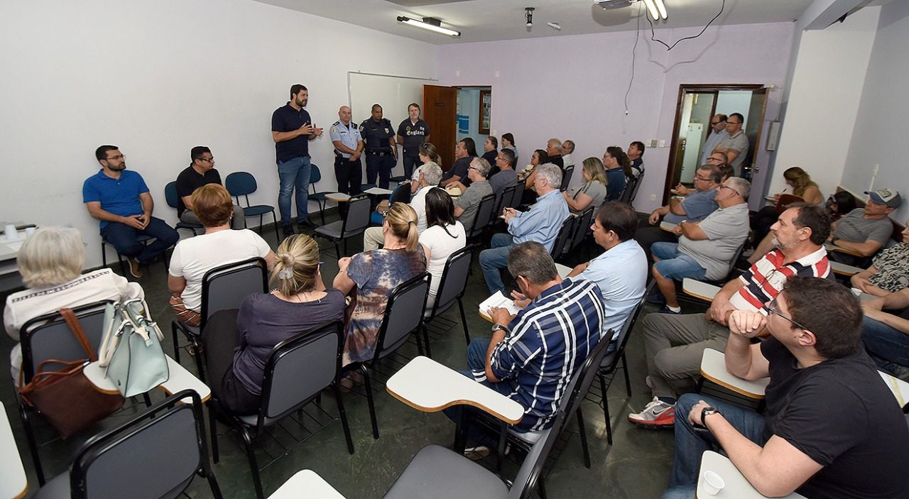 pessoas sentadas numa sala, acompanhando a fala do prefeito Luiz Fernando Machado