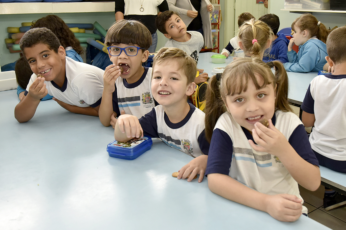 Crianças à mesa comendo biscoitos