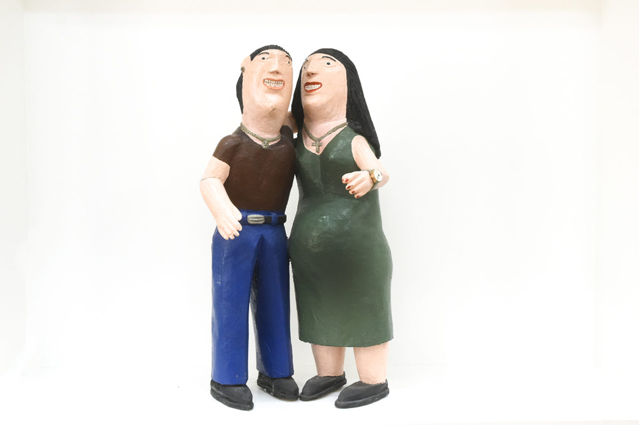 Bonecos de madeira representando figuras masculina e feminina grávida