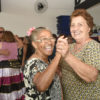 Duas mulheres idosas dançando, sorrindo