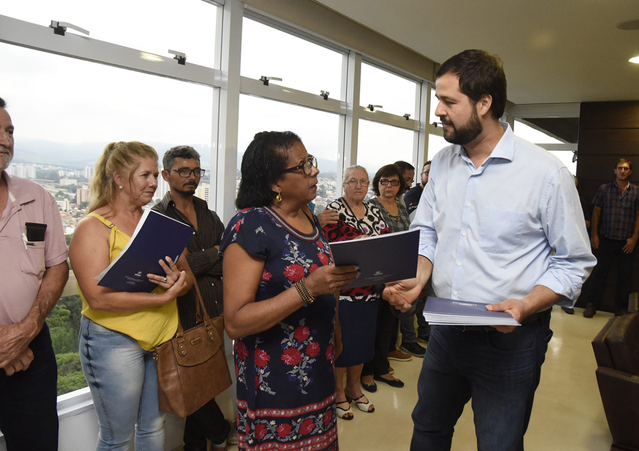 Ana Maria recebe matrícula de seu lote das mãos do prefeito Luiz Fernando