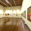 Espaço expositivo com quadros e obras de arte
