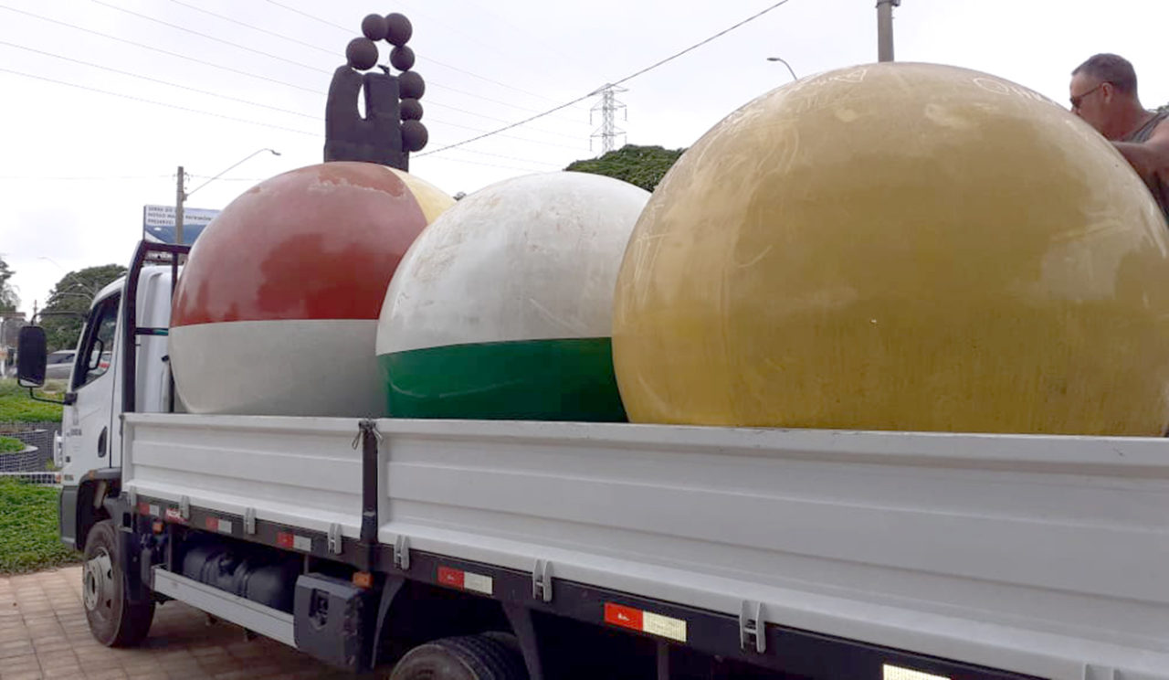 Três esculturas esféricas em cima de um caminhão