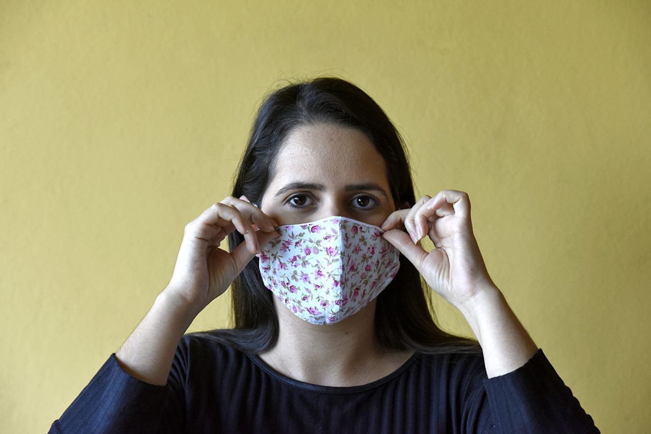 Mulher colocando máscara de proteção individual