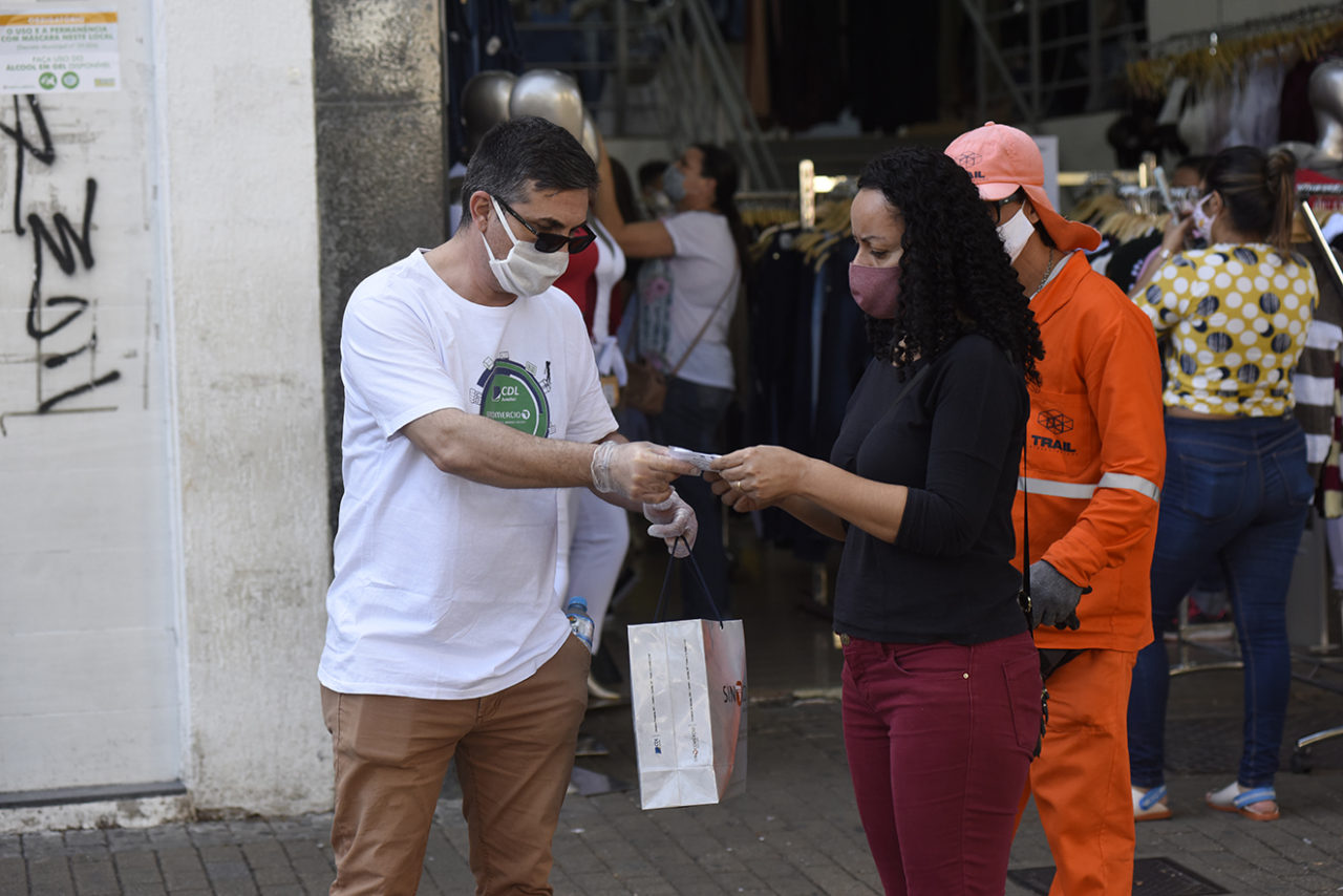 Colaborador da CDL entrega máscara a munícipe na Rua Barão de Jundiaí