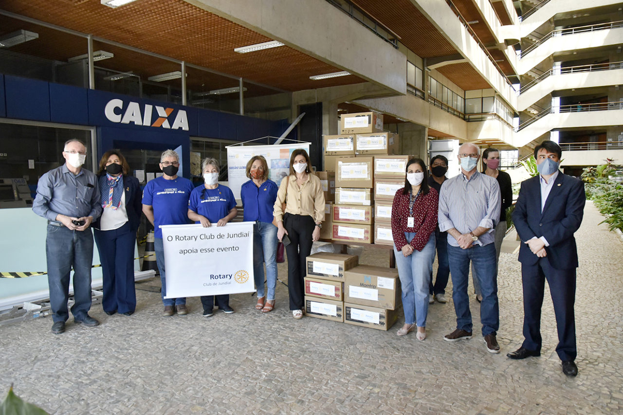 Representantes das unidades Rotary Club de Jundiaí posam ao lado das caixas de equipamentos de proteção individual doados para a Saúde de Jundiaí