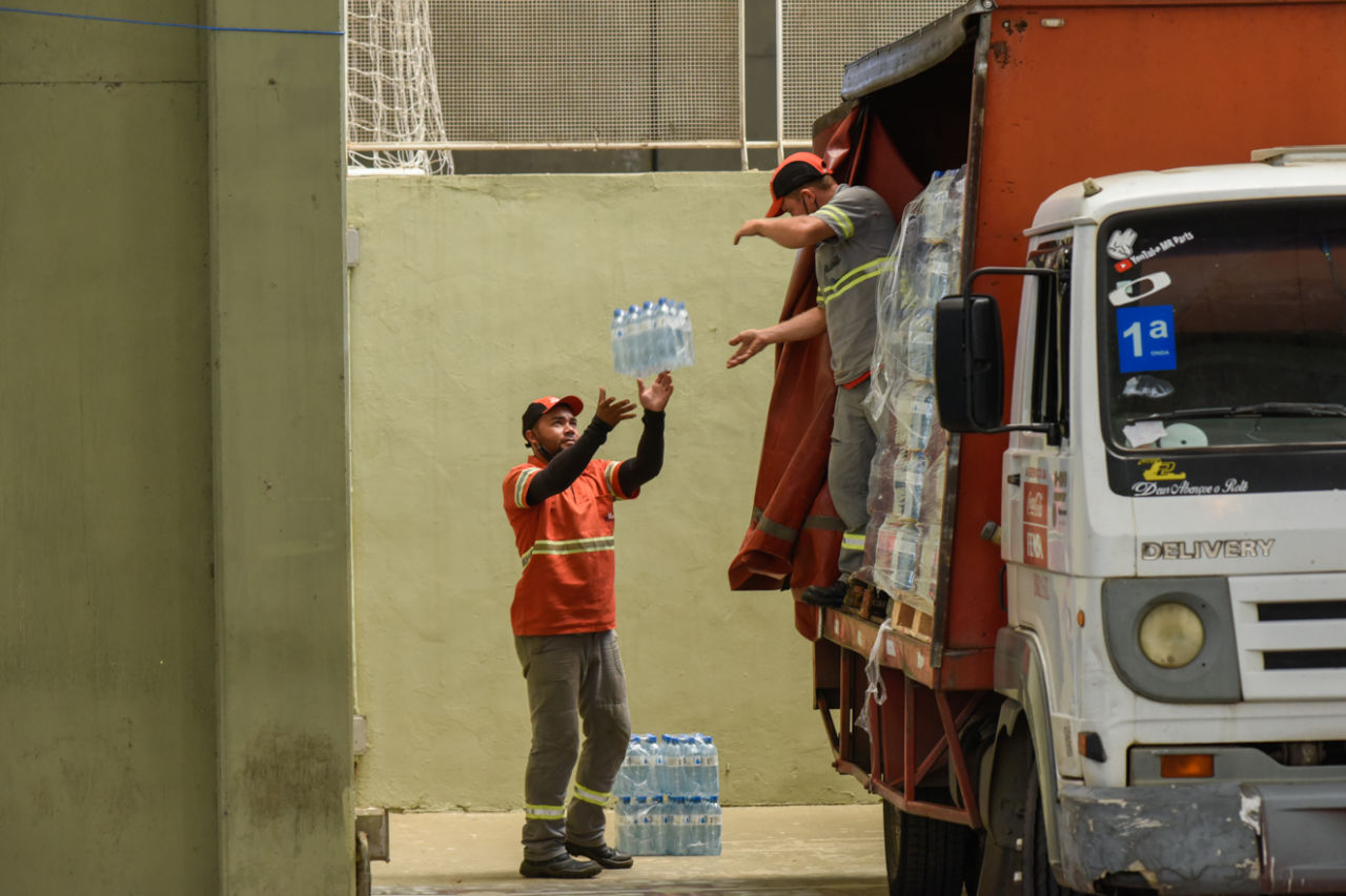 Funcionários da Coca-Cola descarregam água no Parque da Uva