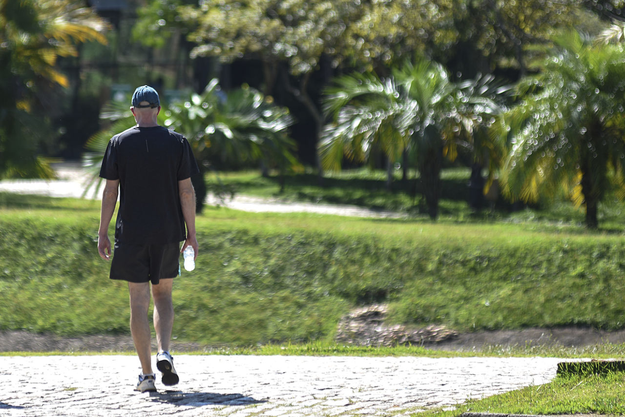 imagem mostra homem caminhando em parque