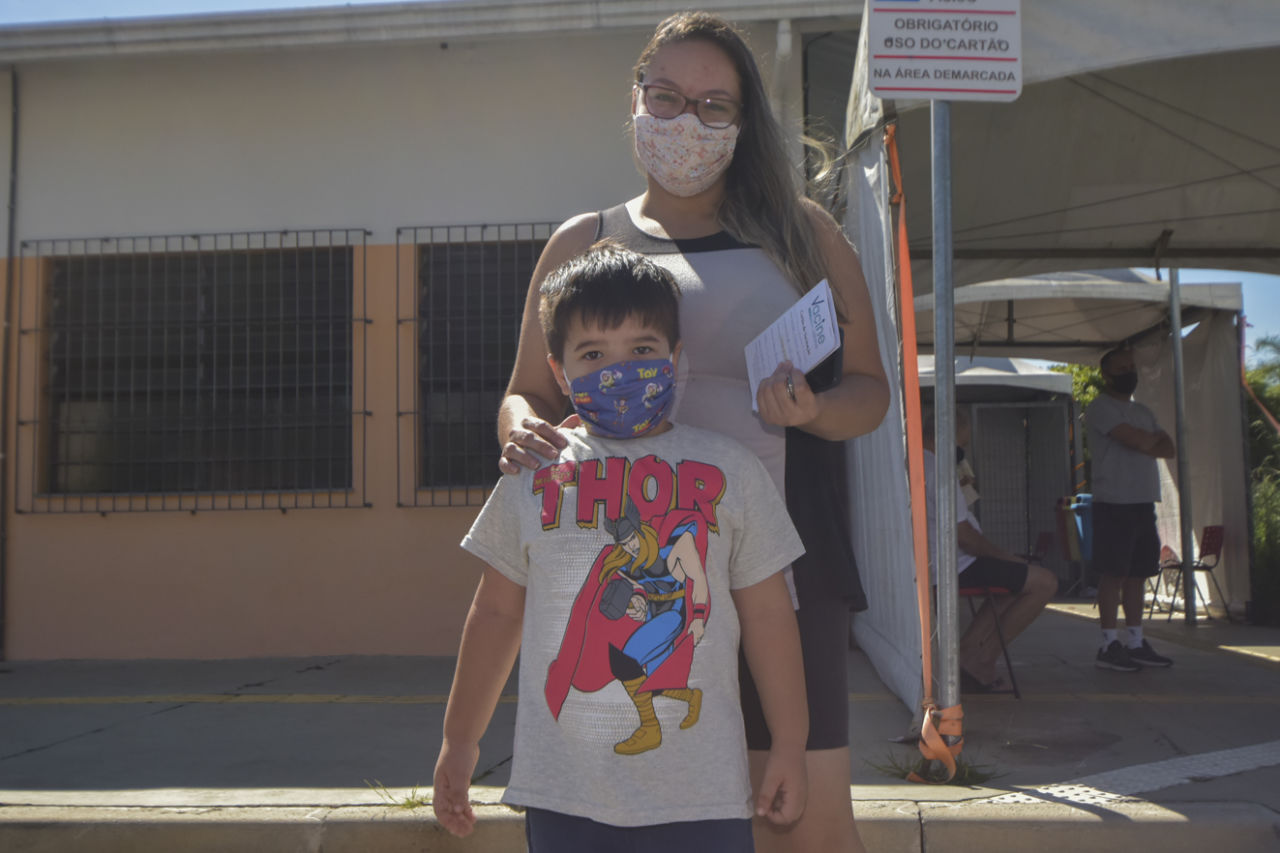 Imagem mostram mulher e criança em frente à Unidade Básica de Saúde