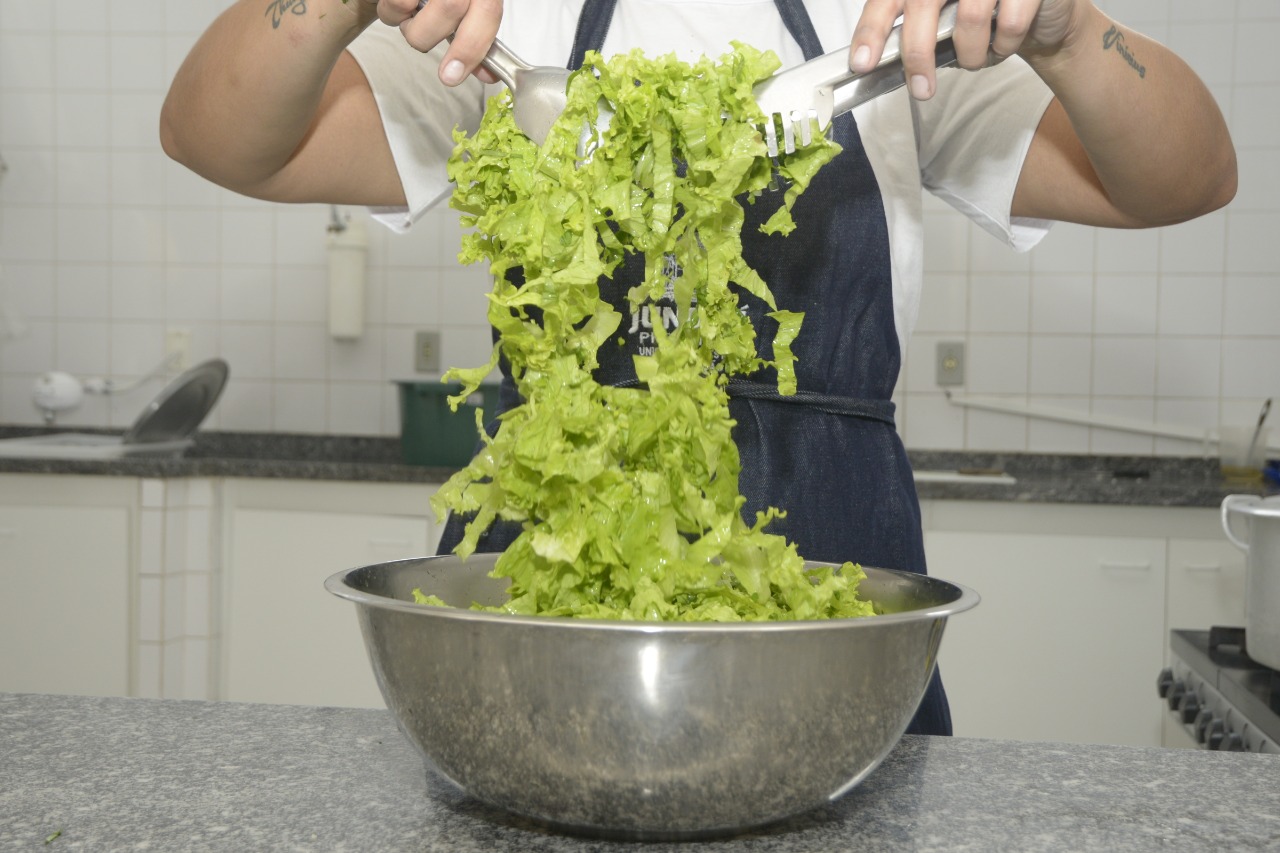 Imagem mostra pessoa mexendo em salada