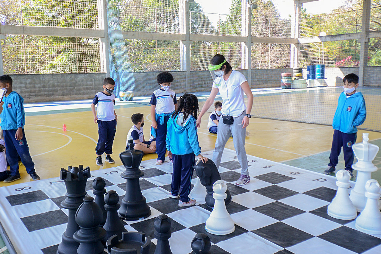 Criança jogando xadrez na aula de escola menino jogando jogo de