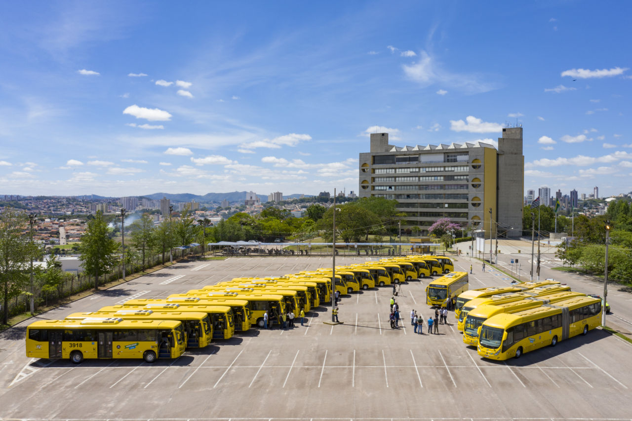 Imagem aérea mostra ônibus estacionados. ao fundo, o Paço Municipal