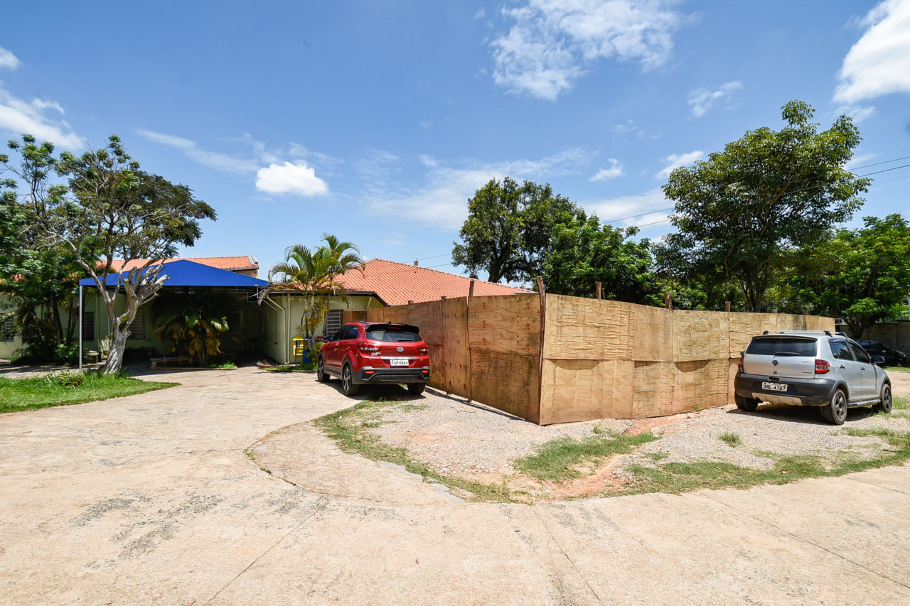 Descrição da imagem: Foto da entrada da Unidade Básica de Saúde do bairro Morada das Vinhas, com cercamento de tapumes de madeira em área que será feita a ampliação do prédio. 