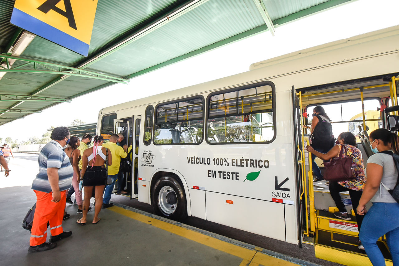 No Terminal Cecap, passageiros sobem pelas duas portas do ônibus elétrico, em cor branca e com detalhes amarelos, parado na plataforma