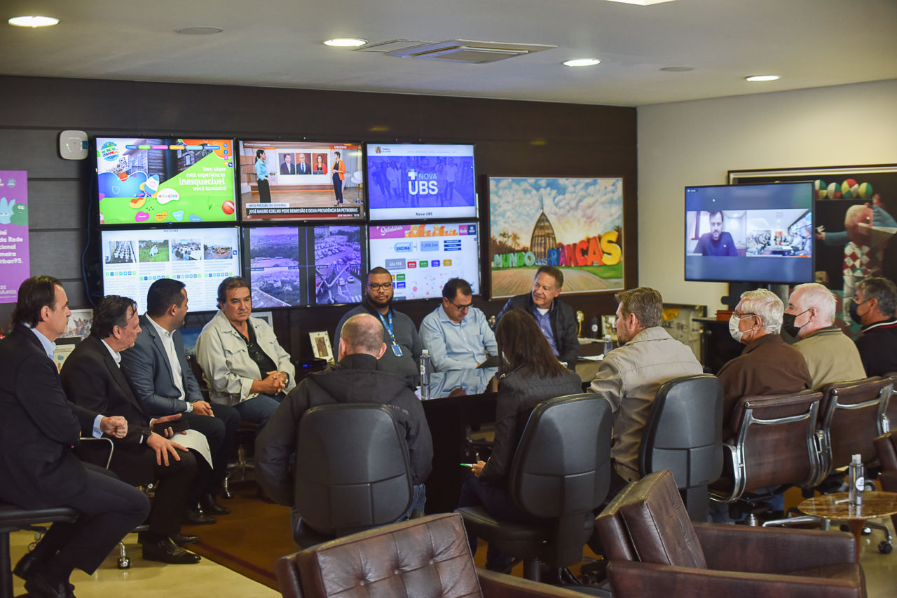 Foto geral, todos sentados. Gestores recebendo moradores do Loteamento Chácara São Jorge no gabinete do prefeito