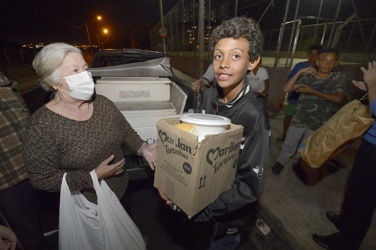 Garoto Davi Guilherme Ferreira, de 11 anos. recebendo as refeições para levar para toda a família