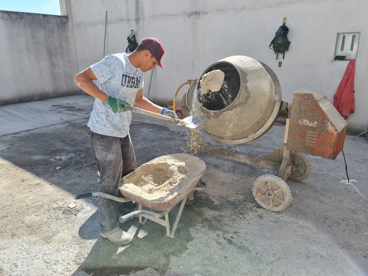 Homem prepara o cimento em uma betoneira