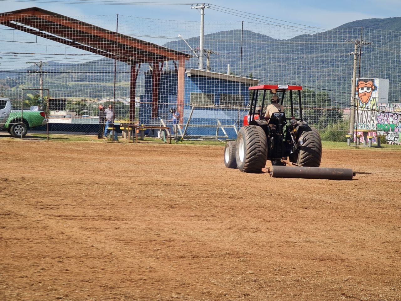 Trator com rolo compressor prepara o campo para receber o novo gramado