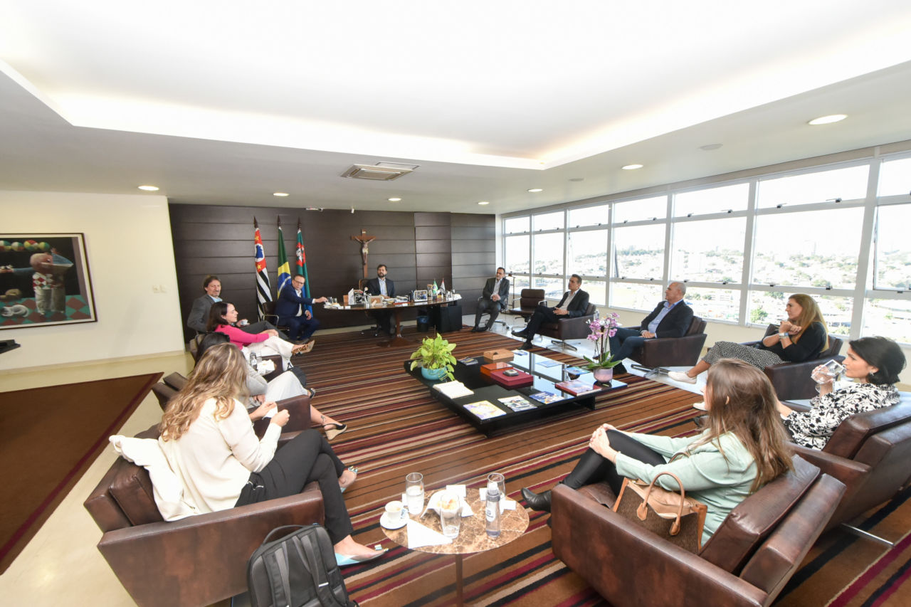 DESCRIÇÃO DE IMAGEM: Foto do gabinete do Prefeito Luiz Fernando Machado, com integrantes do governo, Comgás e Prefeito de Jaguariúna e de Jundiaí, sentados, conversando. Ao lado direito, janela ampla apresenta visão de Jundiaí