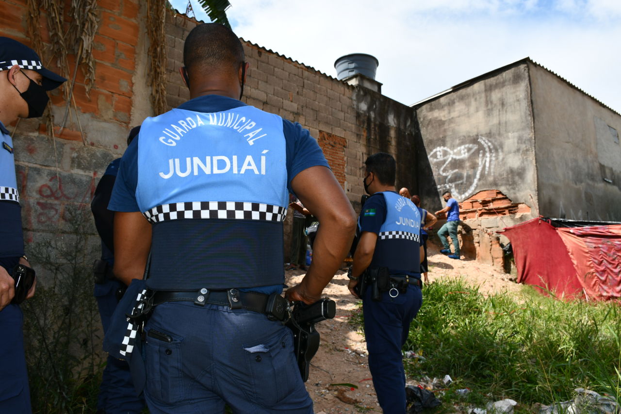 DESCRIÇÃO DA IMAGEM: Guardas municipais uniformizados realização vistoria em área com barracas, para a verificação de situações irregulares