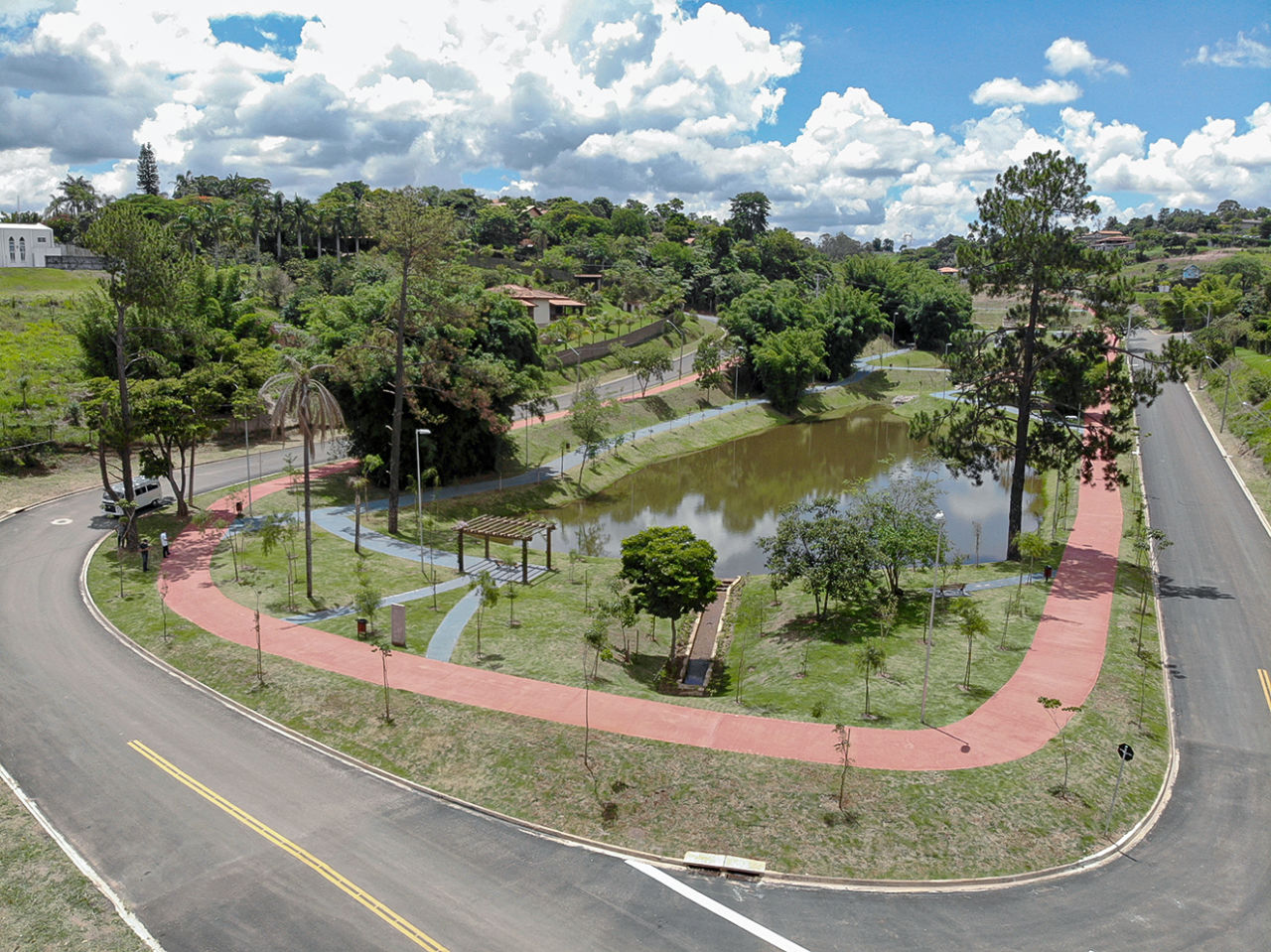 Foto aérea de parque com árvores, pista da corrida e caminhada, lago, pergolado
