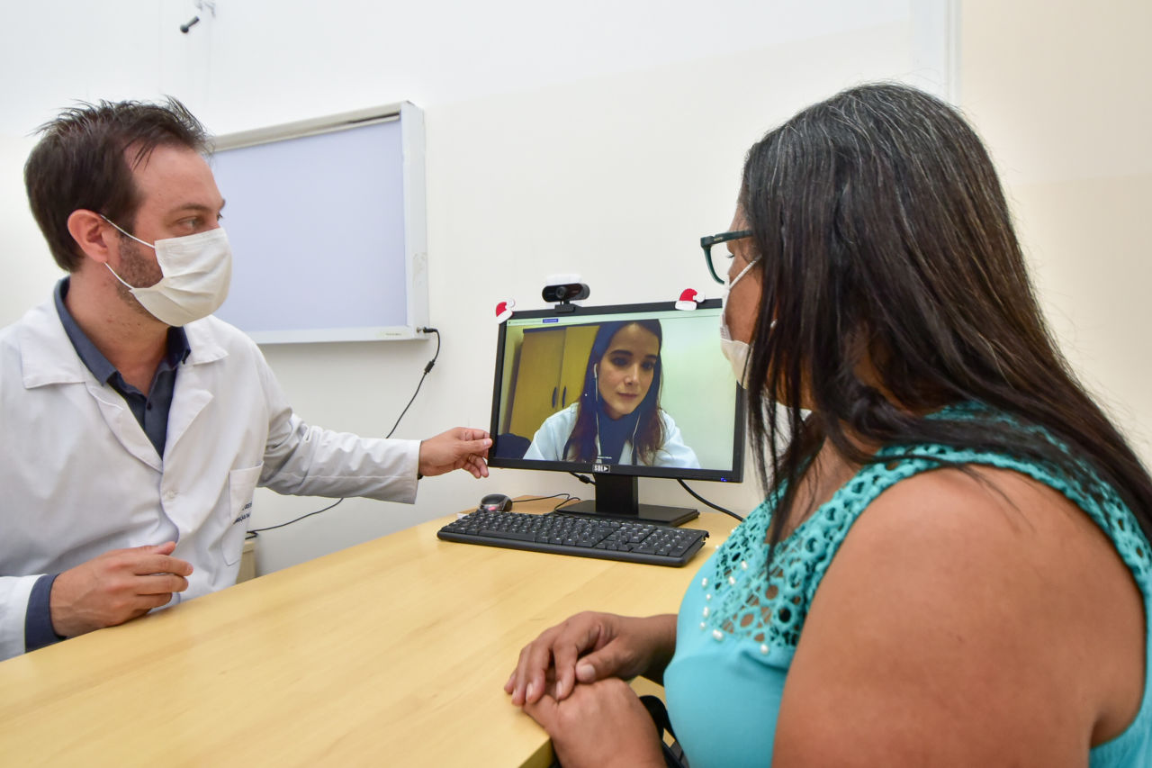 Médico e paciente olhando tela de computador