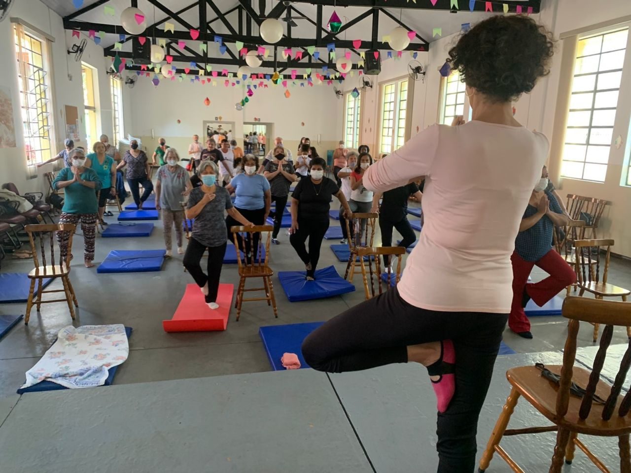 Avós recebem aulas com instrução para atividade de yoga
