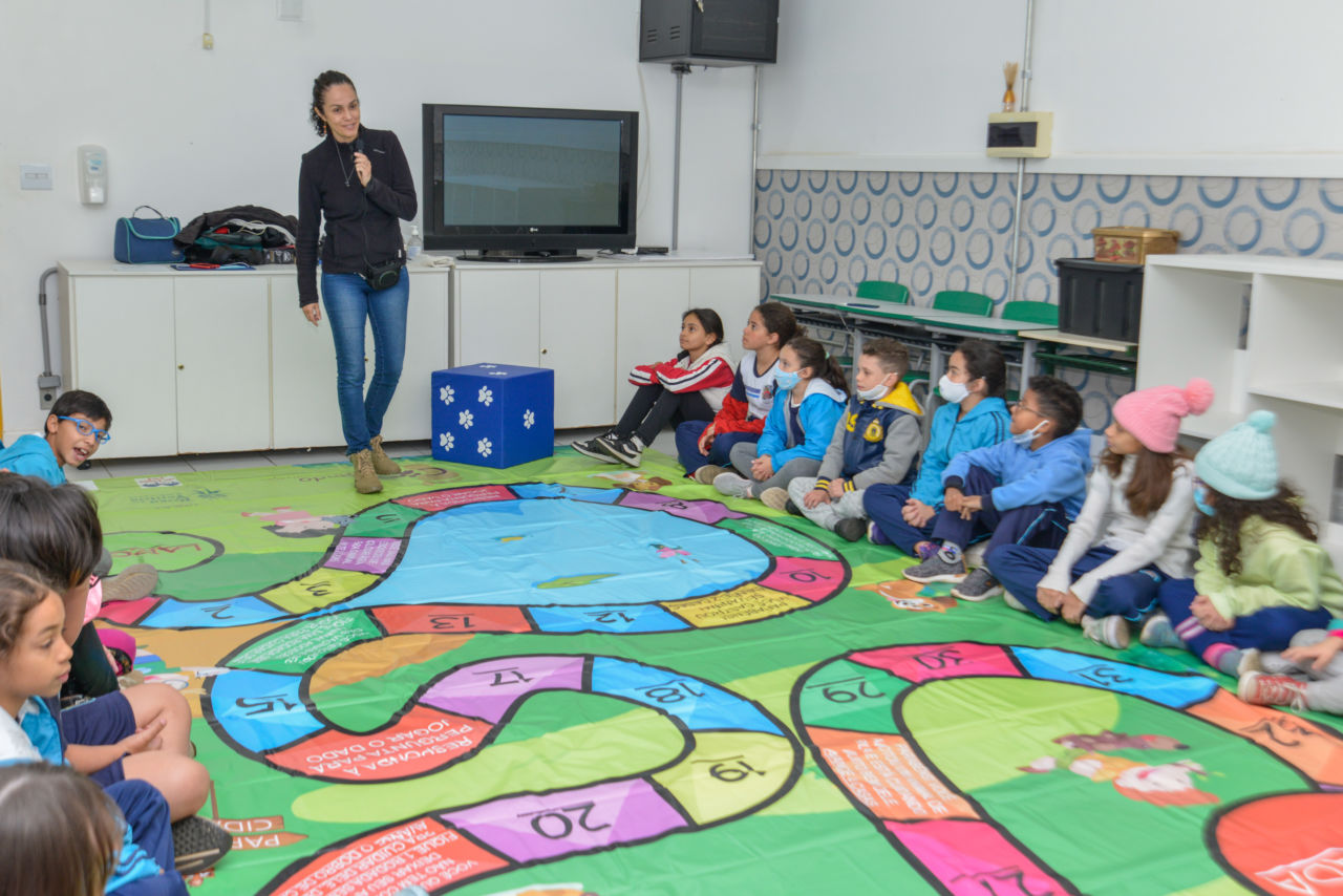 Daniela Araújo realiza brincadeira interativa com alunos do terceiro ano, com dado e tabuleiro 