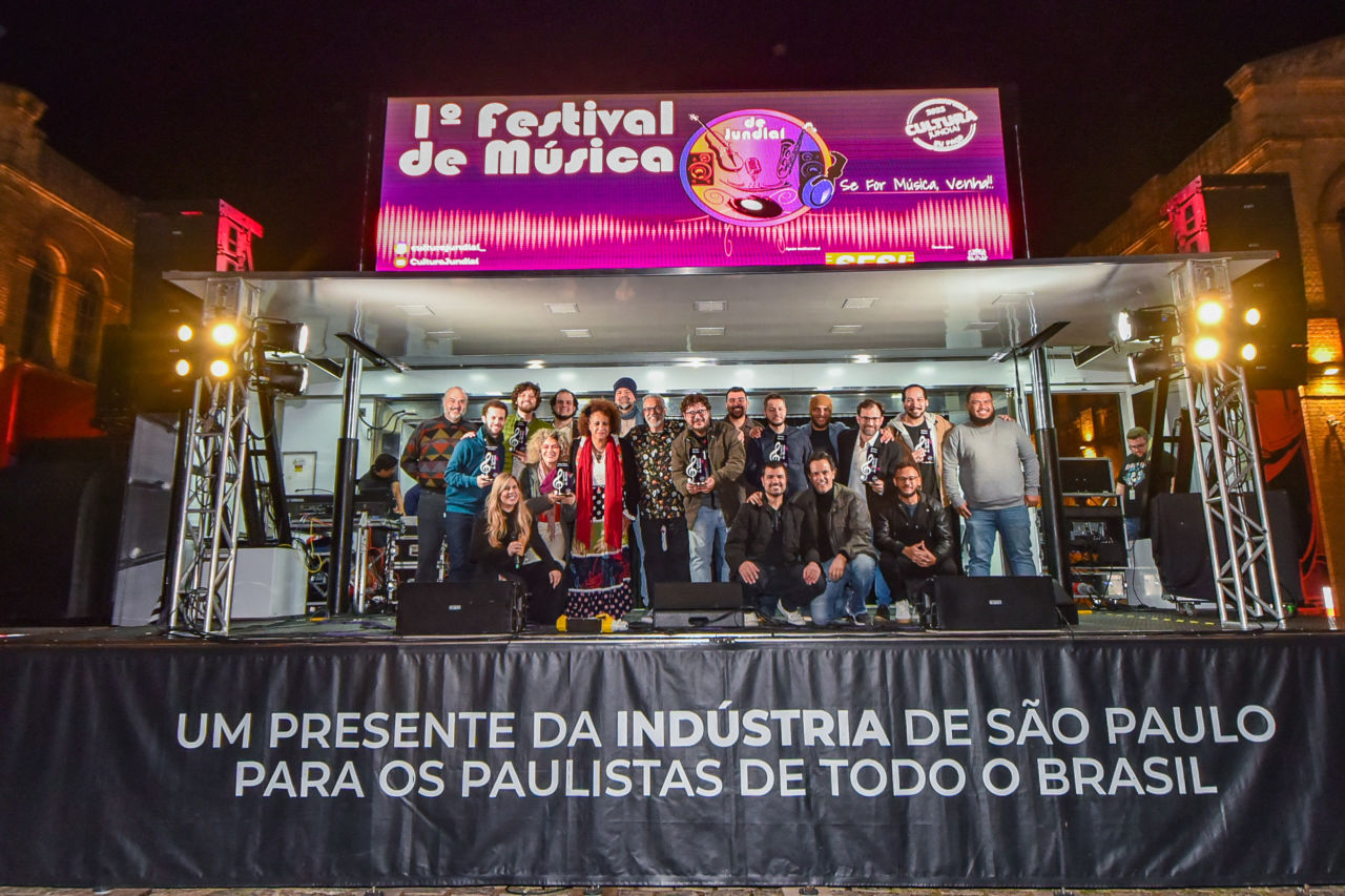Foto geral dos artistas e jurados, em cima do palco do festival