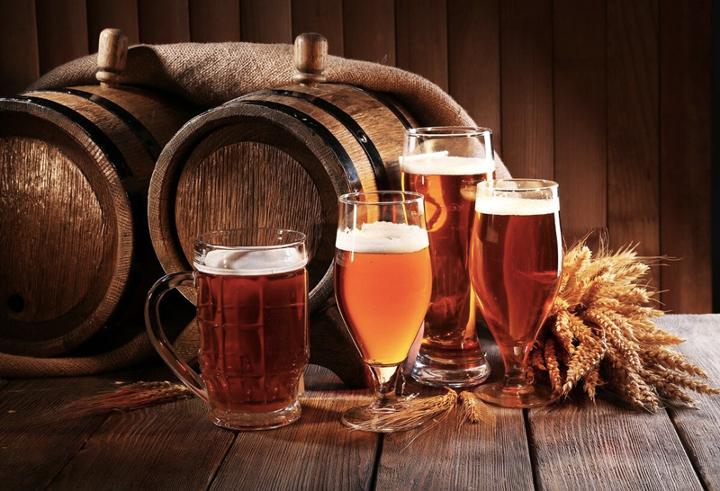 Cervejas artesanais de diferentes tipos sendo exibidas em uma mesa de madeira