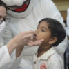 Criança tomando vacina gotas