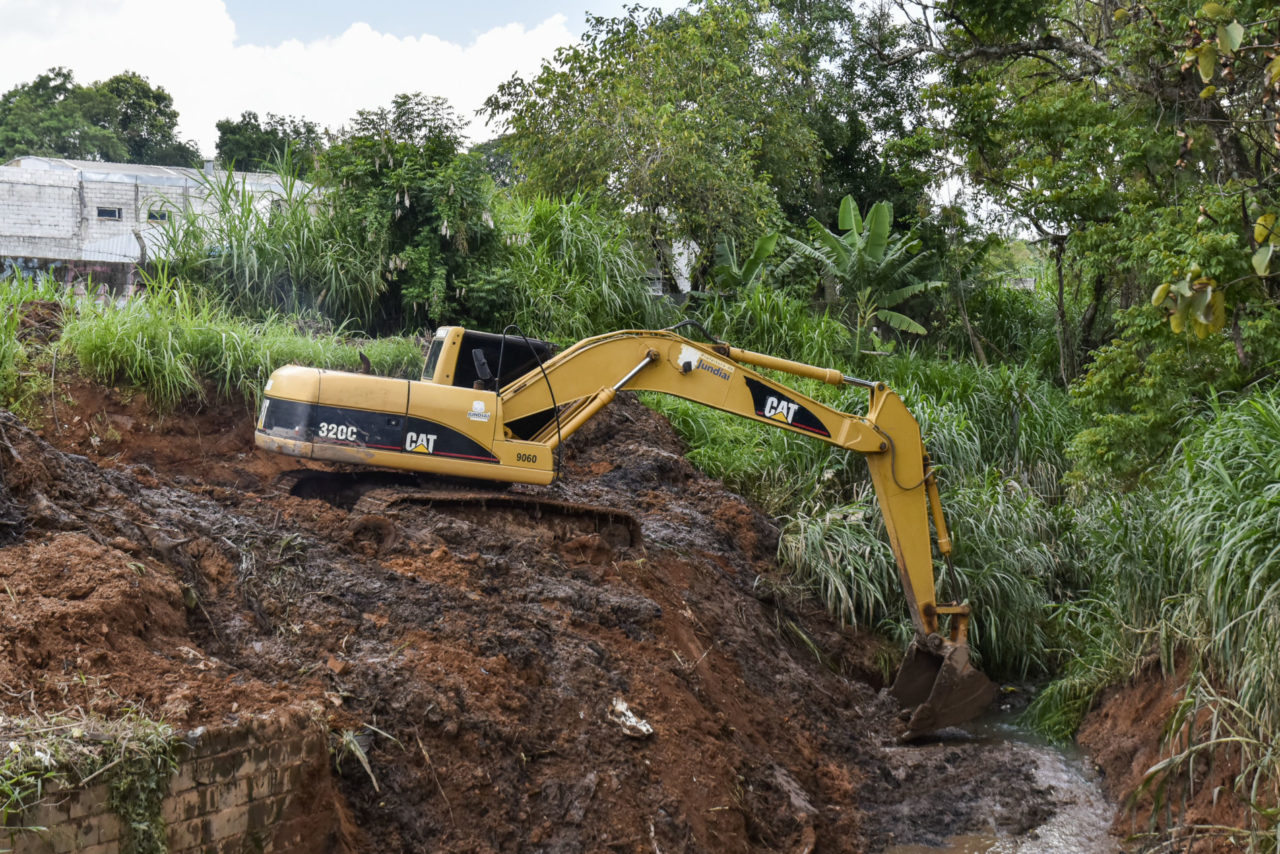 DESCRIÇÃO DA IMAGEM: máquina escavadeira amarela faz a retirada de areia e lodo do fundo de córrego assoreado, na região da Agapeama