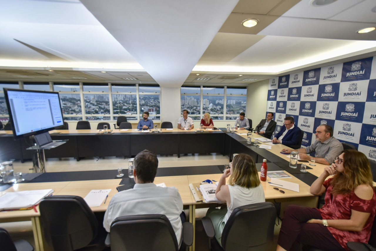 DESCRIÇÃO DE IMAGEM: gestores sentados na sala de reunião do Paço municipal, em apresentação de dados sobre o Plano de Tecnologia da cidade