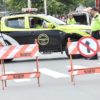 Na foto, agentes de trânsito estão em rua interditada para desfile de bloco de Carnaval, monitorando o movimento para garantir segurança para foliões.